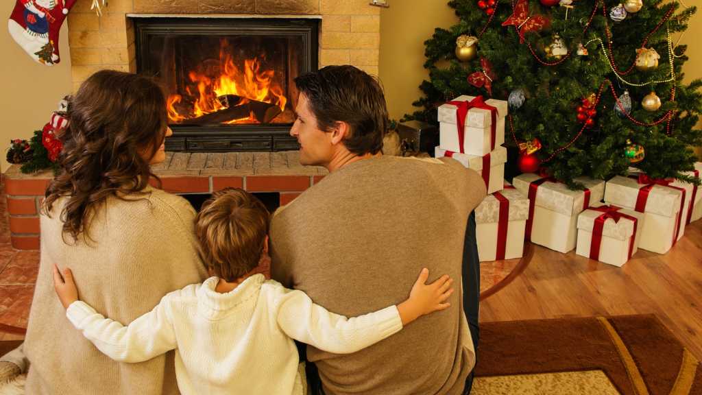 Family sitting by the fireplace during Christmas, representing steps to create an autism-friendly holiday environment.
