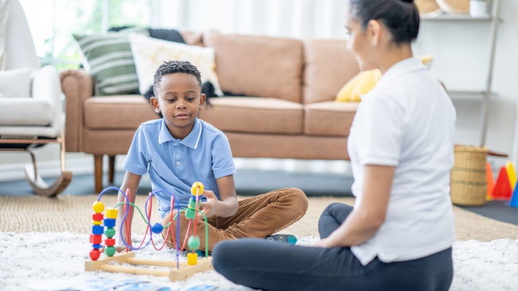 Child participating in a play-based activity with an ABA therapist