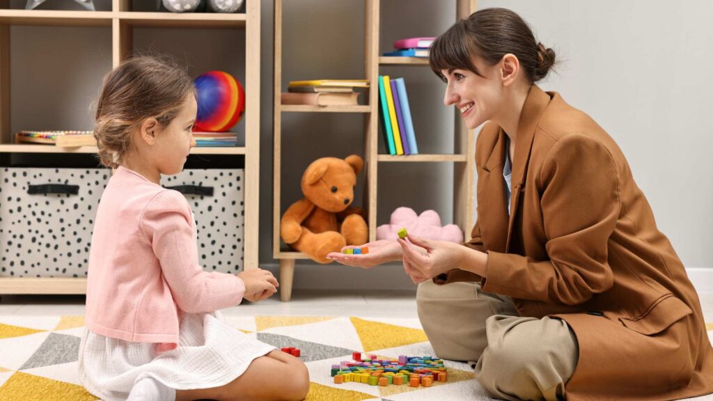 A child engaging in guided play with clinician representing levels of autism through everyday interaction.