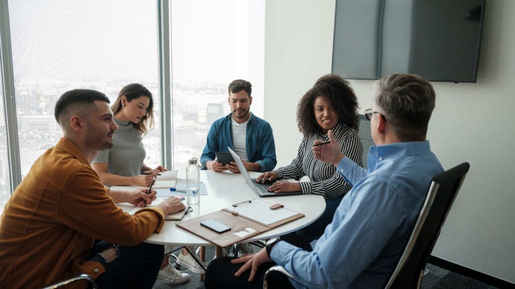 A diverse team in a meeting showing a supportive and successful work environment that values neurodiversity and working with autism.