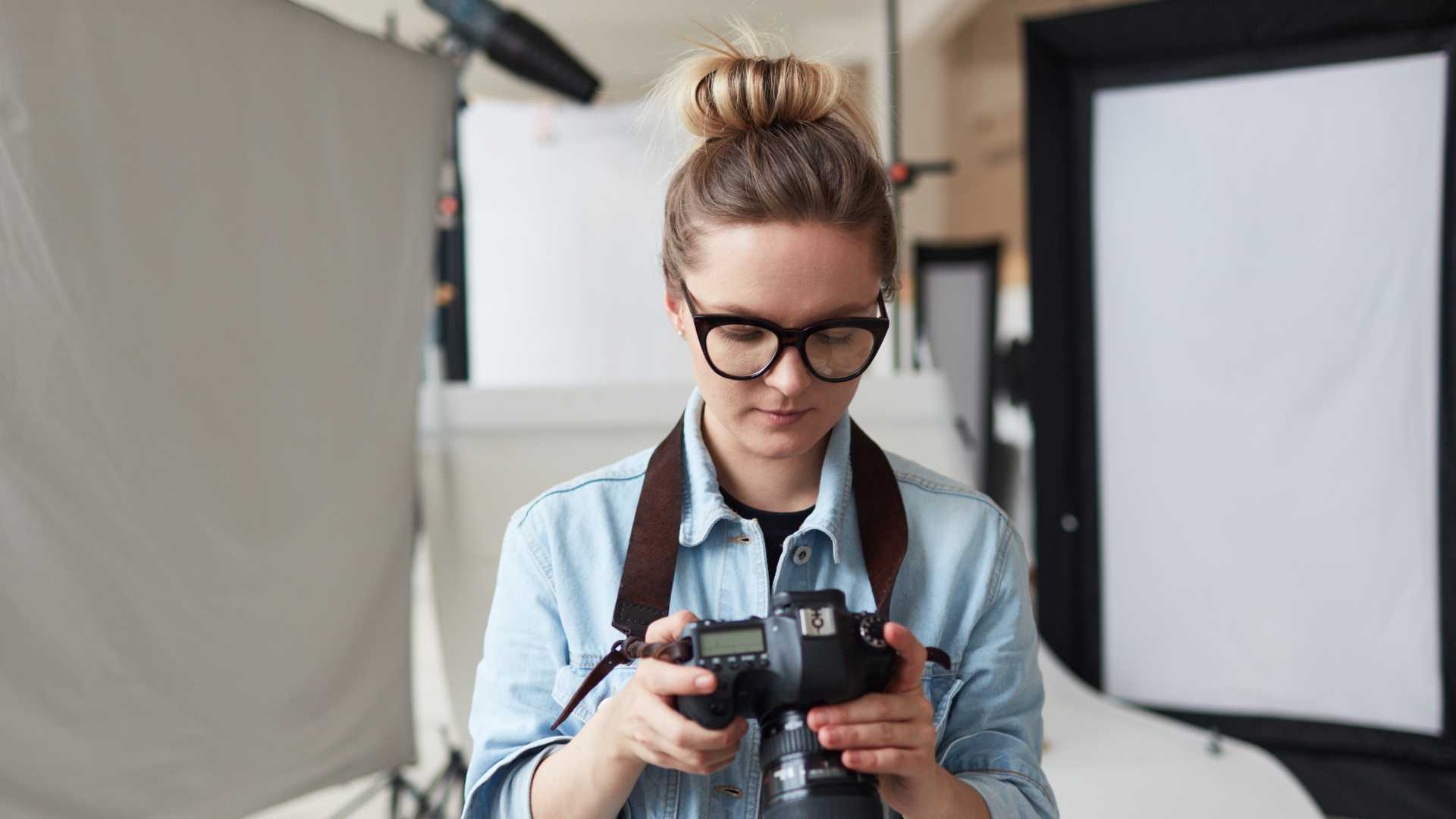 Woman checking her camera settings in a photography studio