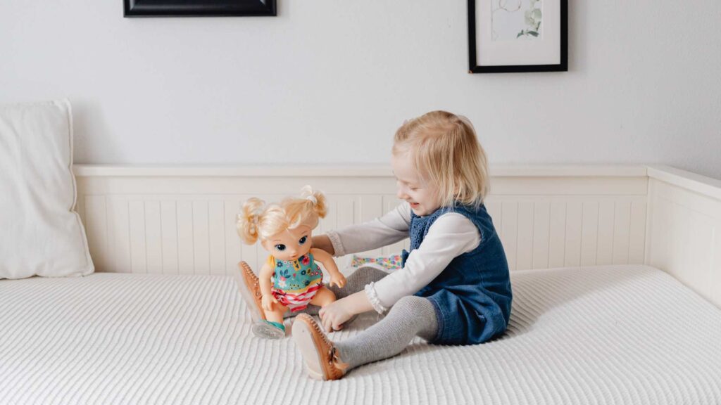 Young kid smiling while interacting with the autistic Barbie