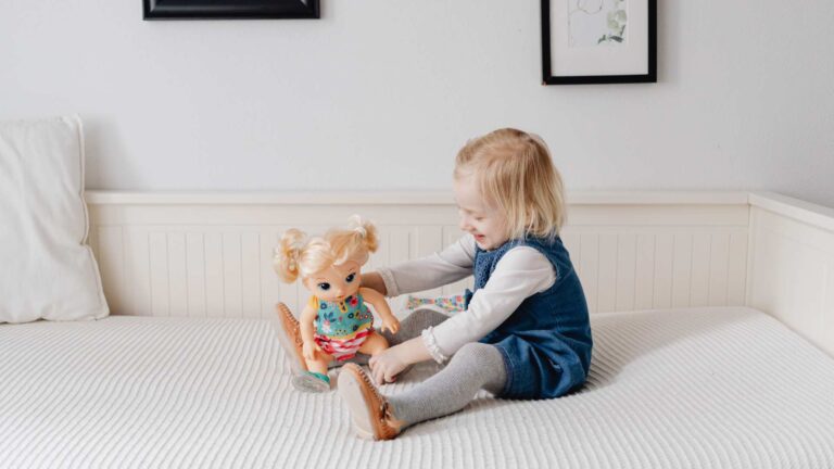 Young kid smiling while interacting with the autistic Barbie