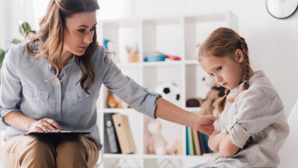 Clinician supporting a child during an M-CHAT autism screening discussion